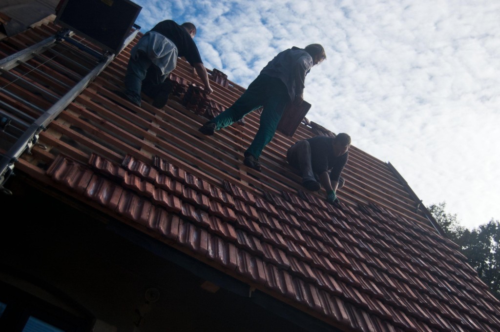 Pokládání vyčištěné a naimpregnované střešní krytiny zpět na střechu